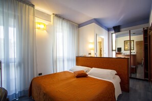 Relax in a spacious room with a large bed, mirror, and wardrobe.
