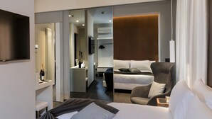 A hotel room with a bed, a chair, a desk, and a TV. - Hotel Metropolitan (Bologna)