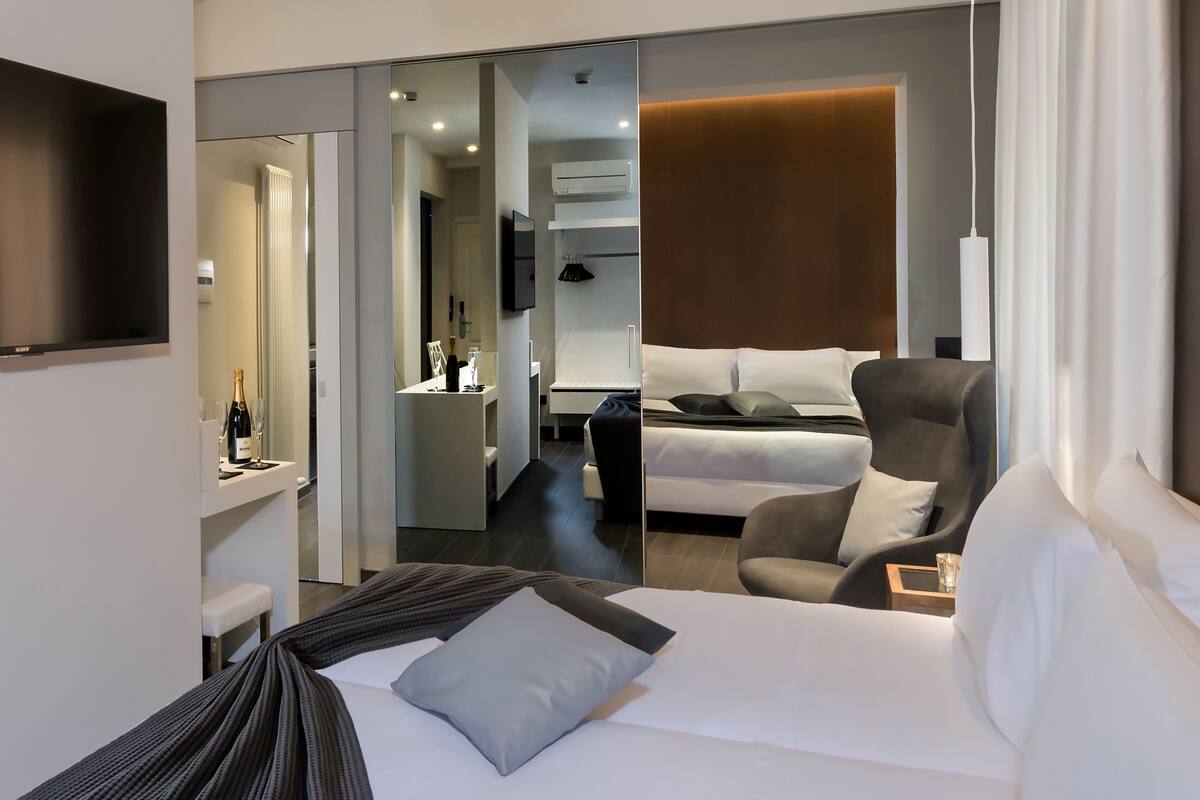 Ein Hotelzimmer mit Bett, Stuhl, Schreibtisch und Fernseher.