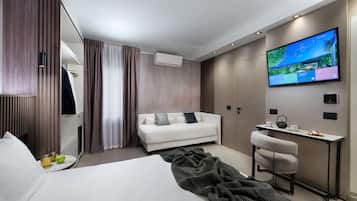 Une chambre d’hôtel moderne équipée d’un lit, d’un canapé, d’un bureau et d’une télévision.