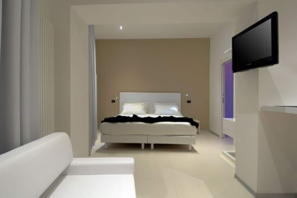 Ein modernes Schlafzimmer mit einem Bett, einem Fernseher und einer Couch.