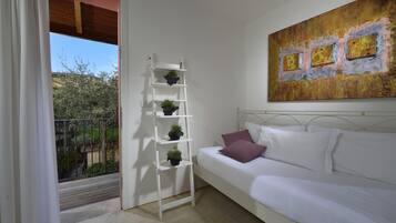 A bedroom with a white bed, a white ladder with potted plants, a balcony with a railing, and a large abstract painting on the wall.