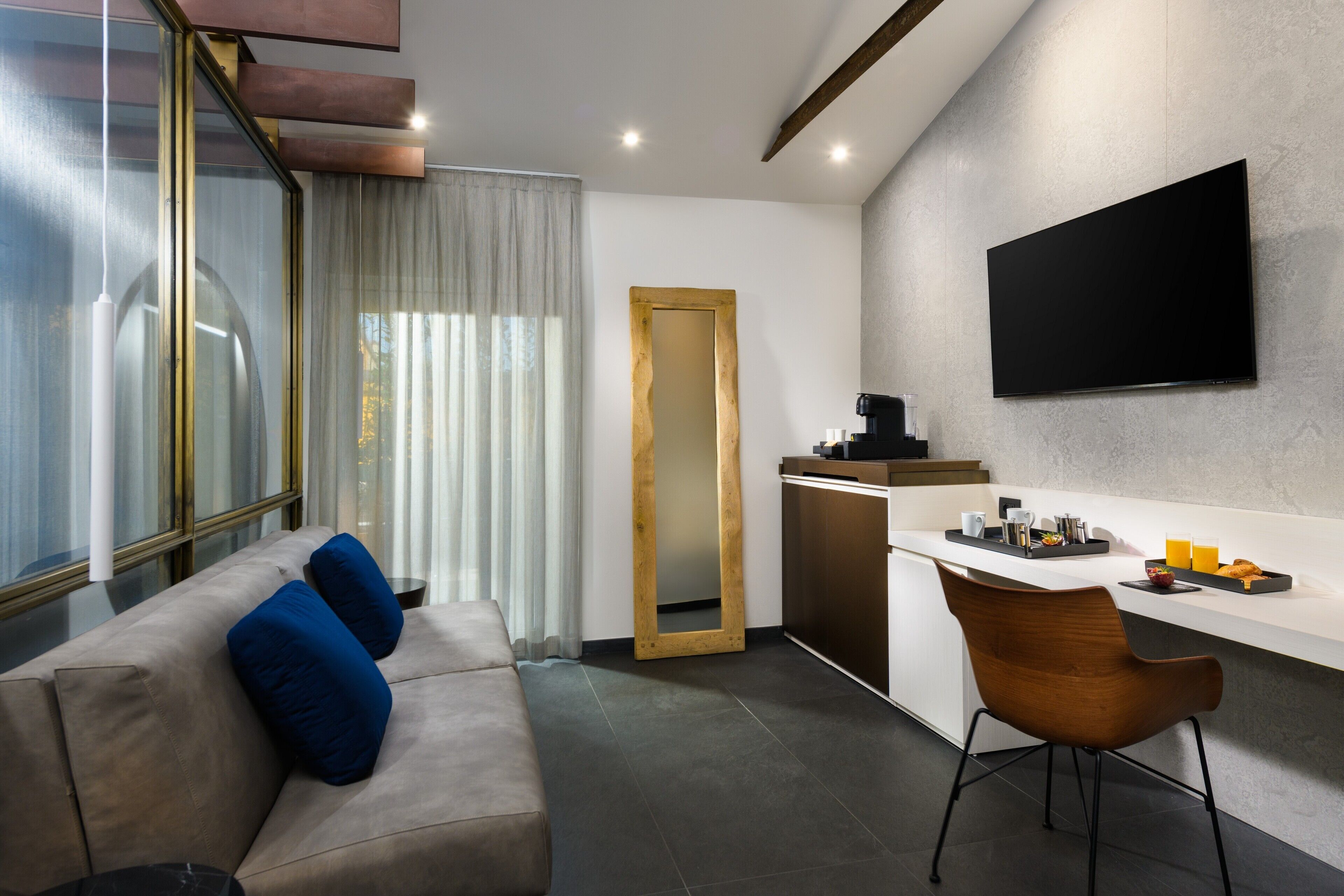 Ein modernes Wohnzimmer mit einer Couch, einem Couchtisch und einem an der Wand befestigten Fernseher.