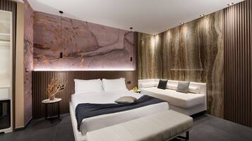 Una camera da letto moderna con un letto grande, un divano e una parete decorativa.