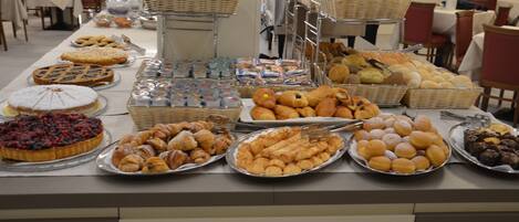 Un bufé con diversas opciones de panadería y pastelería.