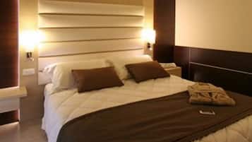 Una habitación de hotel moderna con una cama grande, cabecera de madera y lámparas de noche.