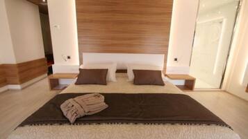Une chambre moderne avec un grand lit, deux tables de chevet et un miroir.