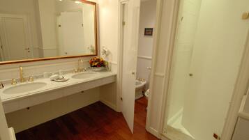 Une salle de bain avec deux lavabos, un grand miroir et une douche.