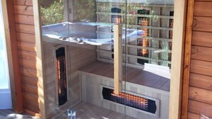 Una sauna con puertas de cristal, paredes de madera y vistas a un edificio de ladrillo.