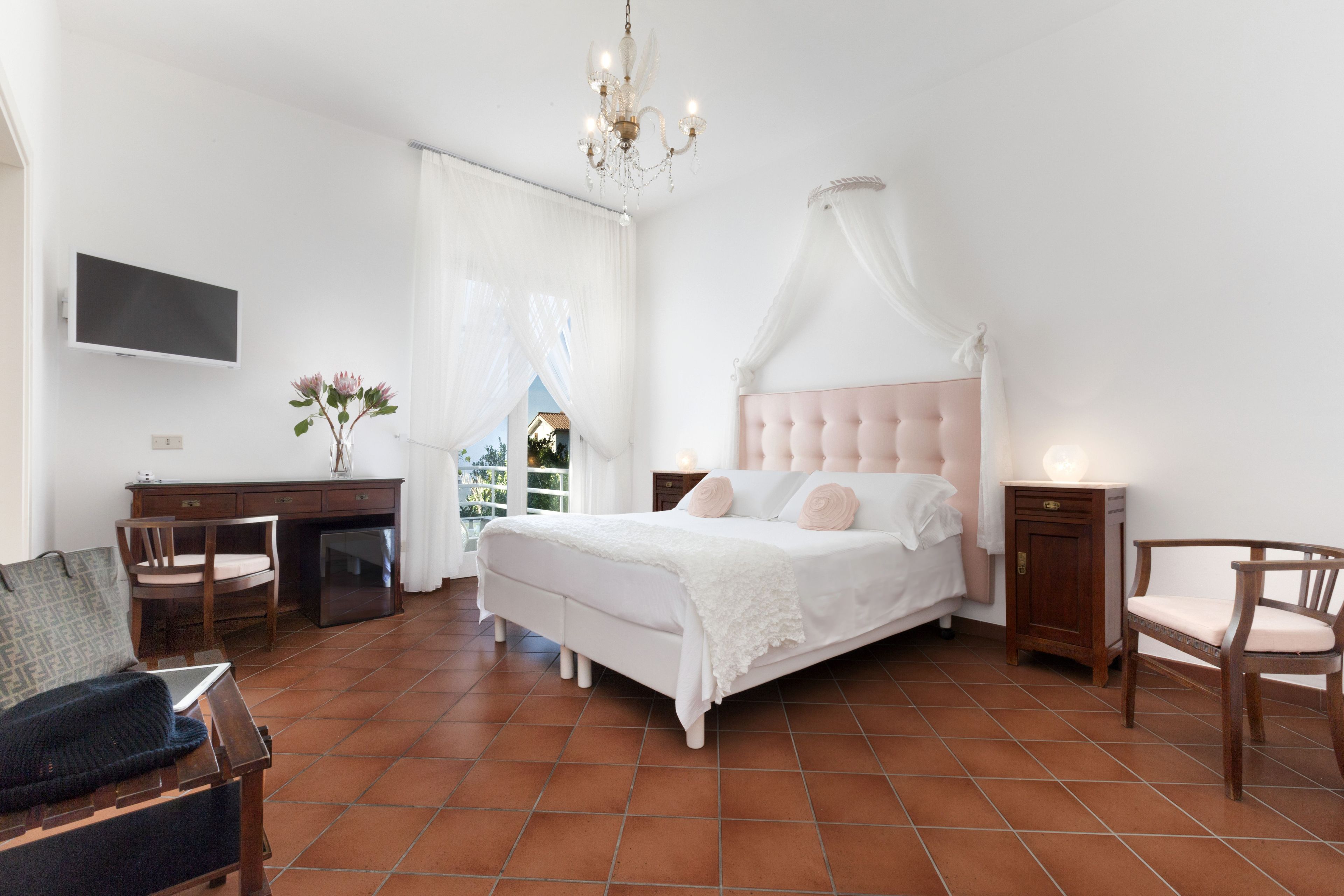 Une chambre à coucher avec un lit, un bureau, une chaise et un téléviseur.