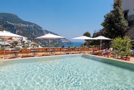Una piscina al aire libre de temporada, sillones reclinables de piscina
