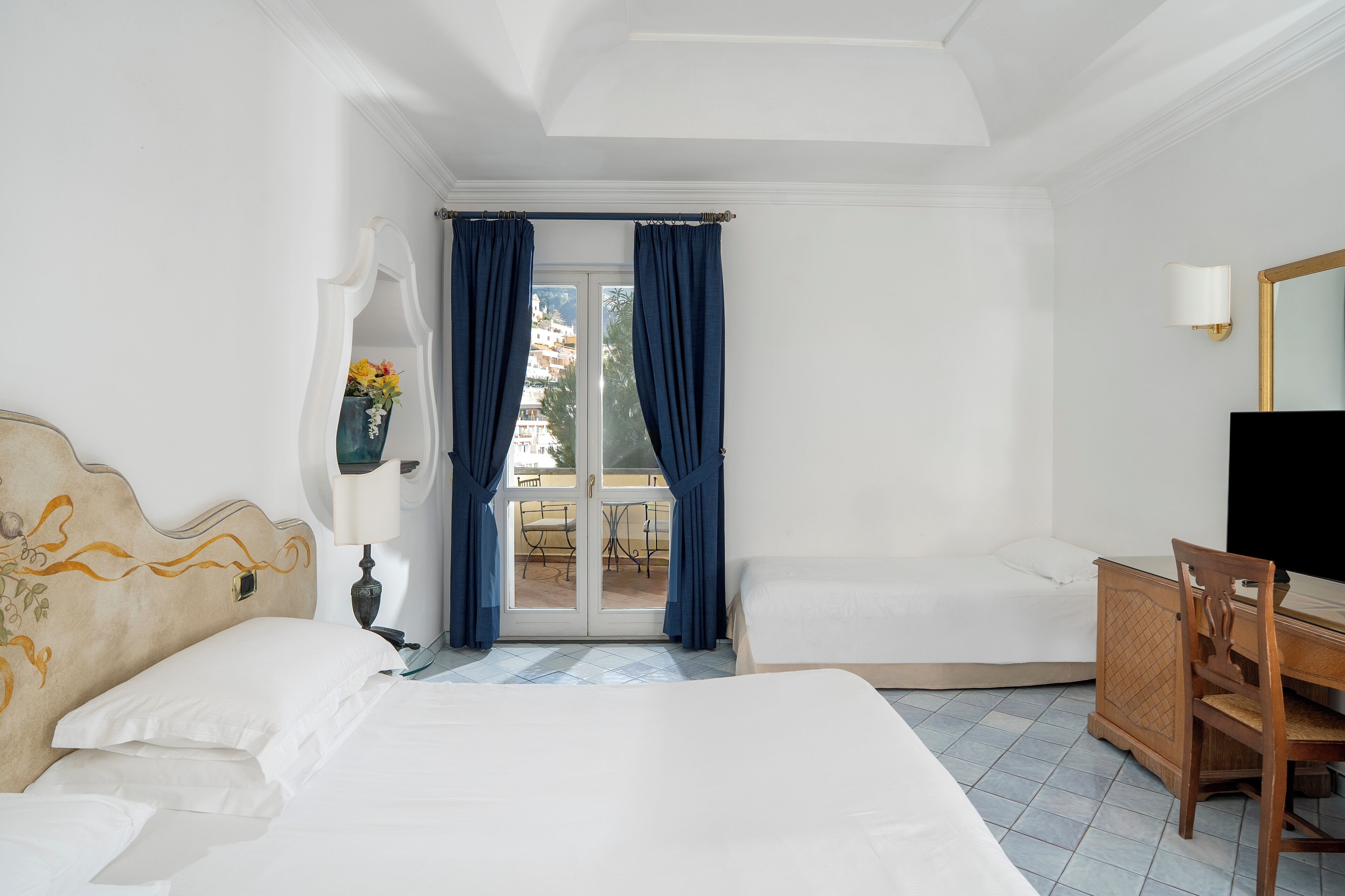 Deluxe driepersoonskamer, gedeeltelijk uitzicht op zee | Donsdekens, een minibar, een kluis op de kamer, een bureau