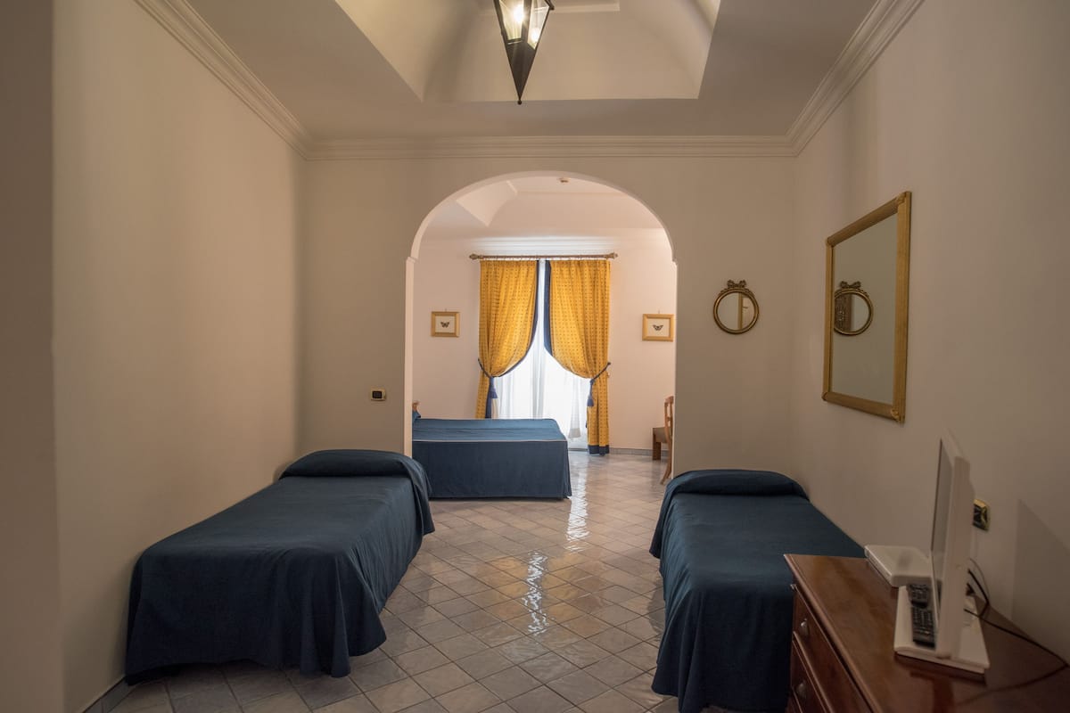 deluxe quadruple room, partial sea view | 1 bedroom, down duvets, minibar, in-room safe