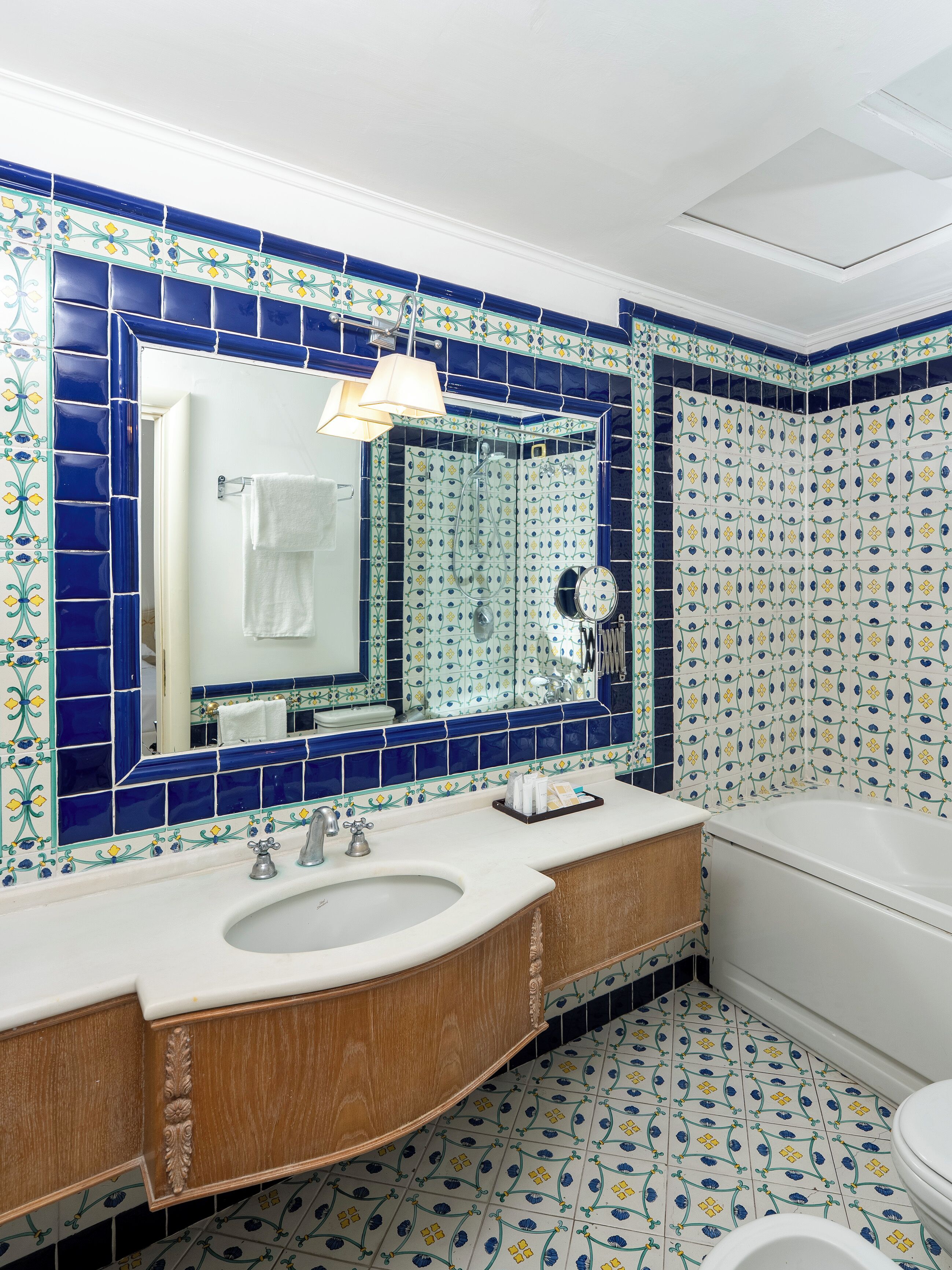 Une salle de bain avec un grand miroir, un lavabo et une baignoire.