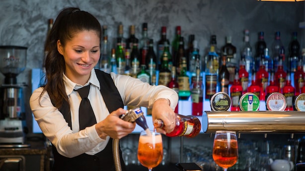 Un barman verse une boisson dans un verre.