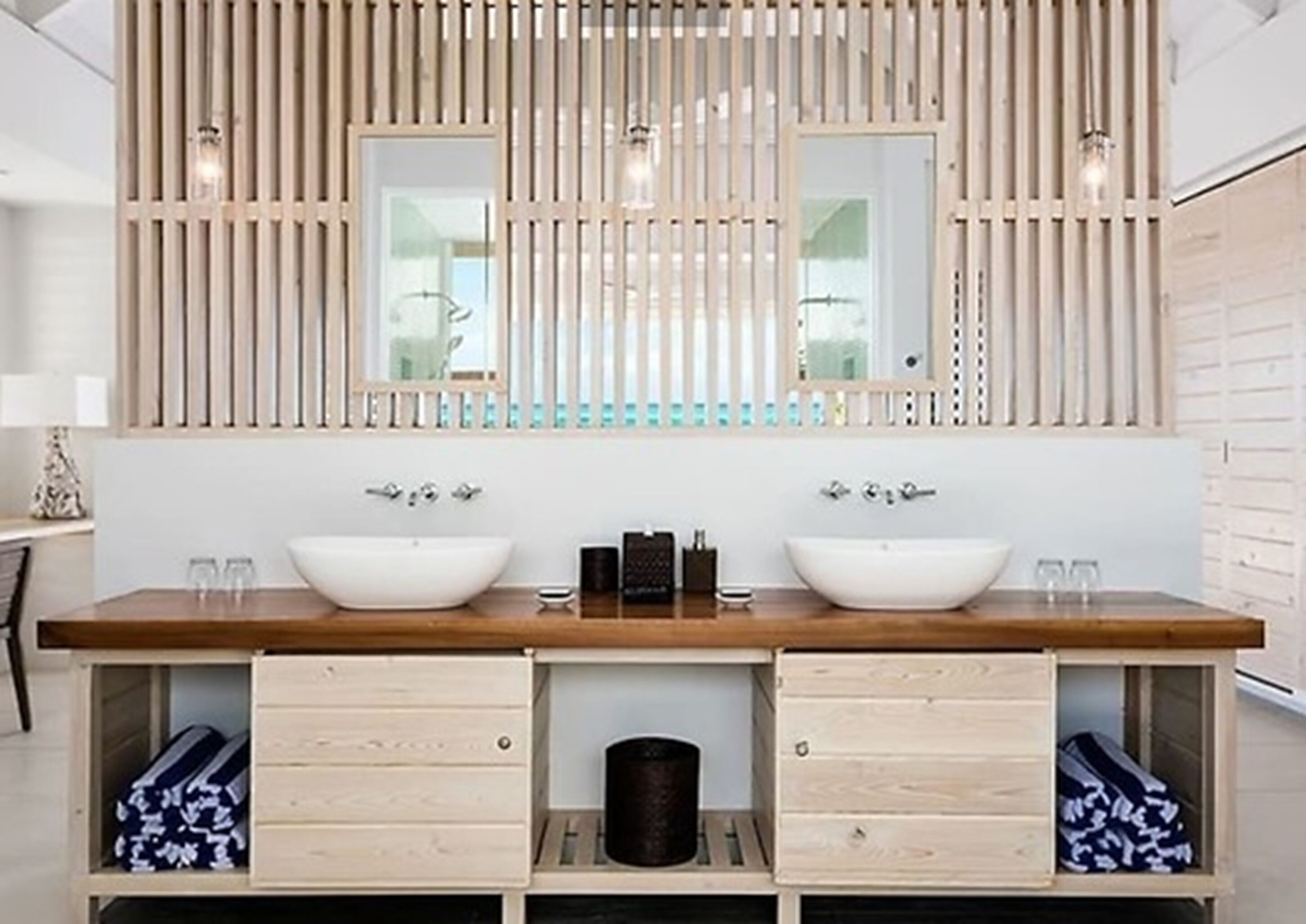 A modern bathroom with a wooden vanity, two sinks, and a mirror above.