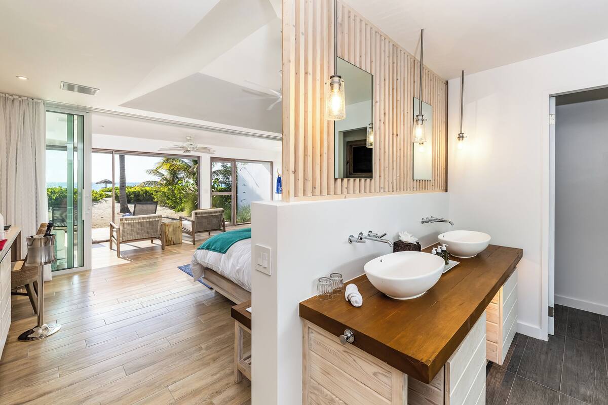 A modern bathroom with a wooden vanity, two sinks, and a large mirror.