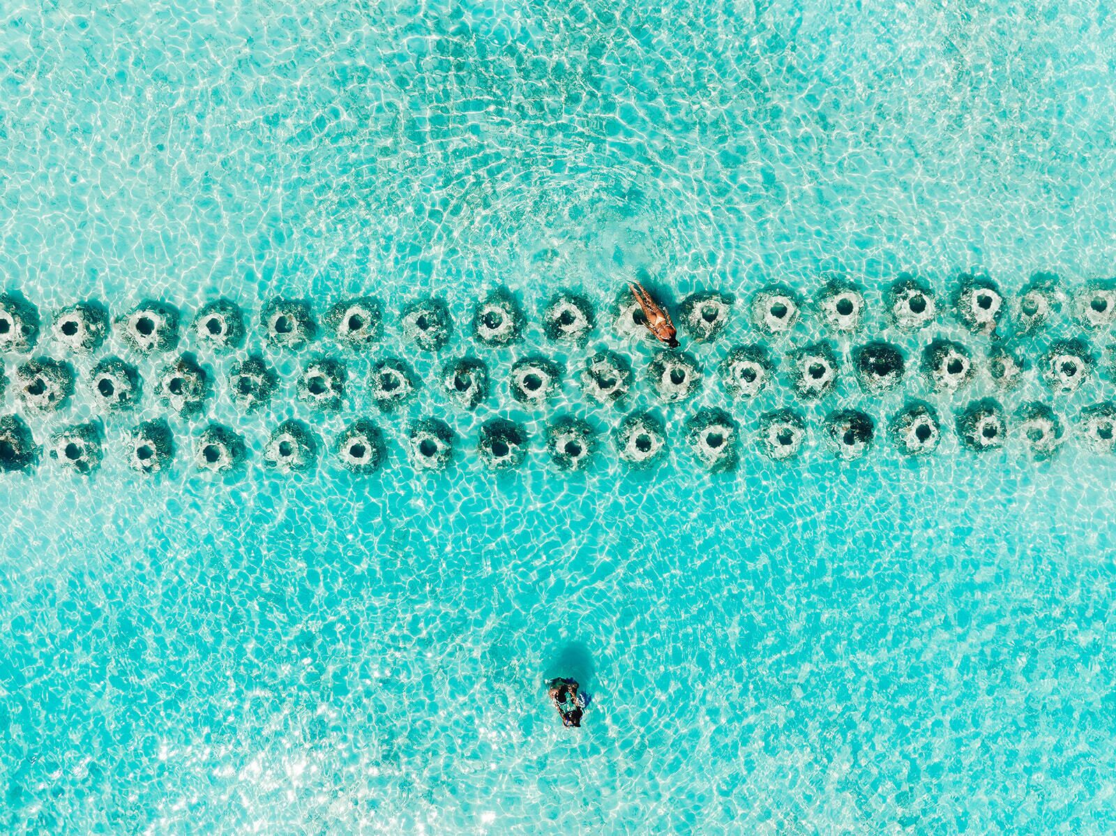 Vista clara de una piscina con varios patrones circulares en la superficie, probablemente causados por una fuente o sistema de filtración.