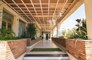 Walkway leads to the main entrance of a well-maintained building with large windows.