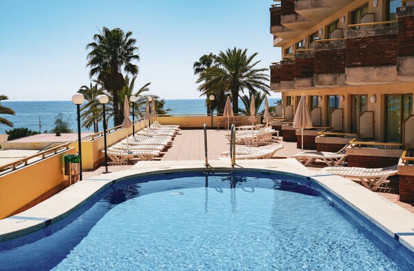 Piscine extérieure, parasols, chaises longues