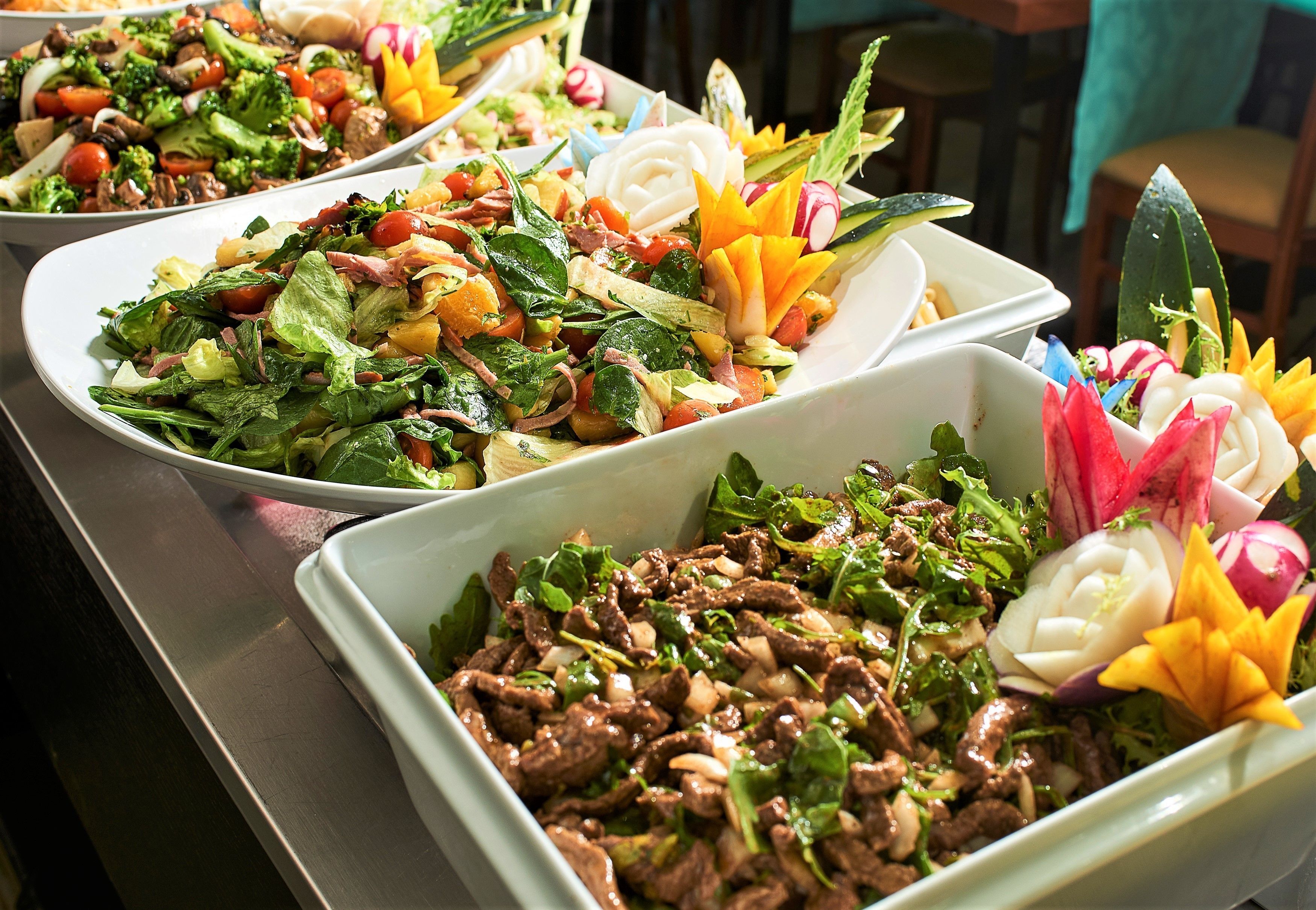 A buffet with various dishes including salads, meats, and vegetables.