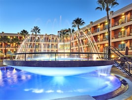 Una piscina cubierta, una piscina al aire libre, sombrillas, tumbonas