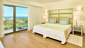 A hotel room with two beds, a balcony with a view, and a wooden floor. - Hotel Baia Grande (Albufeira)