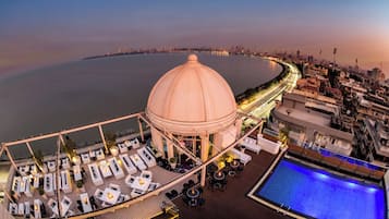 Une terrasse sur le toit dotée d’une piscine, d’un espace salon et offrant une vue sur le panorama urbain.