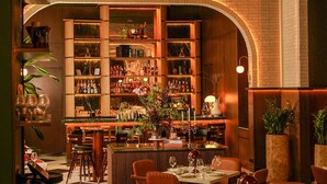 A bar area with shelves of liquor bottles, a bar counter, and seating for guests. - InterContinental Marine Drive Mumbai by IHG (Mumbai)