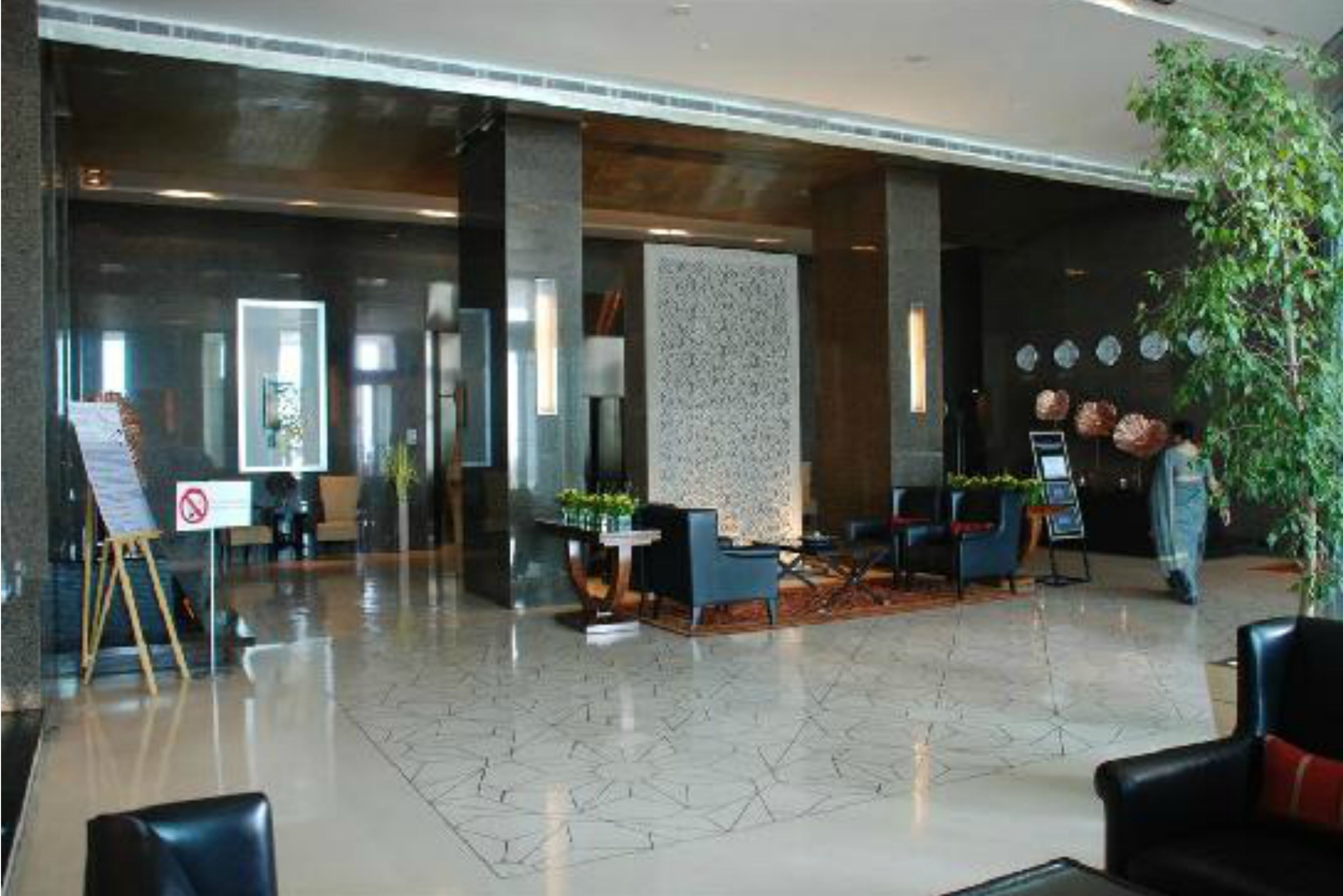 Eine moderne Lobby mit einer Rezeption, einer Sitzecke und einer großen Wanddekoration.
