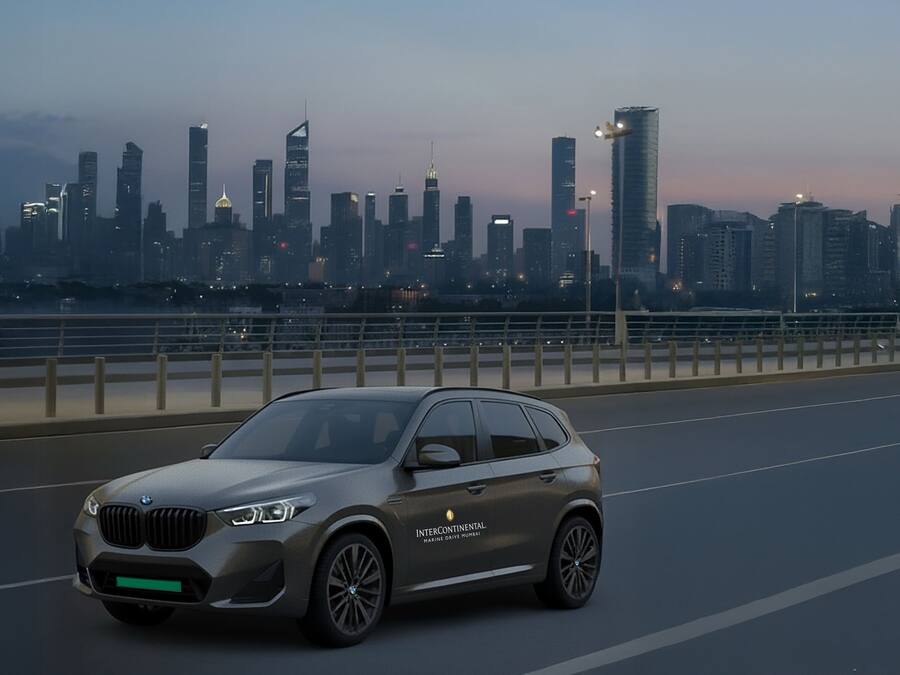 Ein BMW SUV auf einer Brücke mit einer Stadtkulisse im Hintergrund.