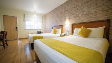 Une chambre d’hôtel avec deux lits, un plancher en bois, un mur décoratif en briques et une fenêtre avec des stores.