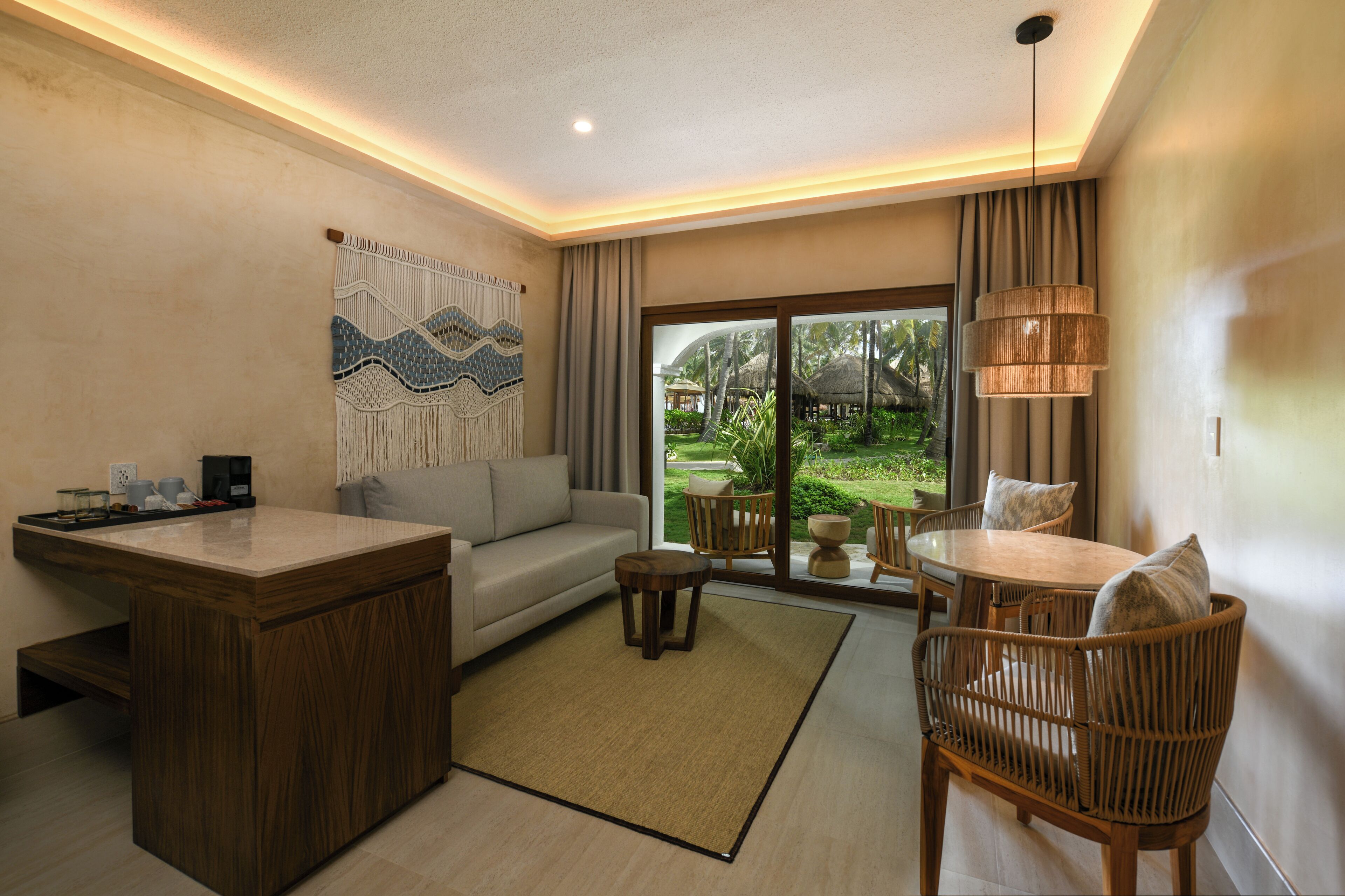 A modern living room with a sofa, coffee table, and dining area.