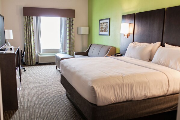 A hotel room with a large bed, a desk with a lamp, a chair, and a window with curtains. - Holiday Inn Express & Suites Sweetwater by IHG (Sweetwater)