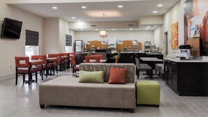 A hotel lobby with a seating area, a reception desk, and a kitchenette. - Holiday Inn Express & Suites Sweetwater by IHG (Sweetwater)