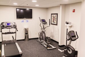 A fitness room with treadmills, an elliptical, and a stationary bike.