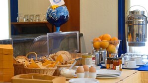 En frukostbuffé med bröd, ägg och apelsiner.
