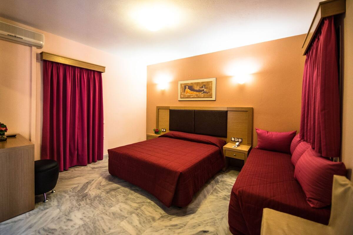 A hotel room with two beds, a desk, and a nightstand.