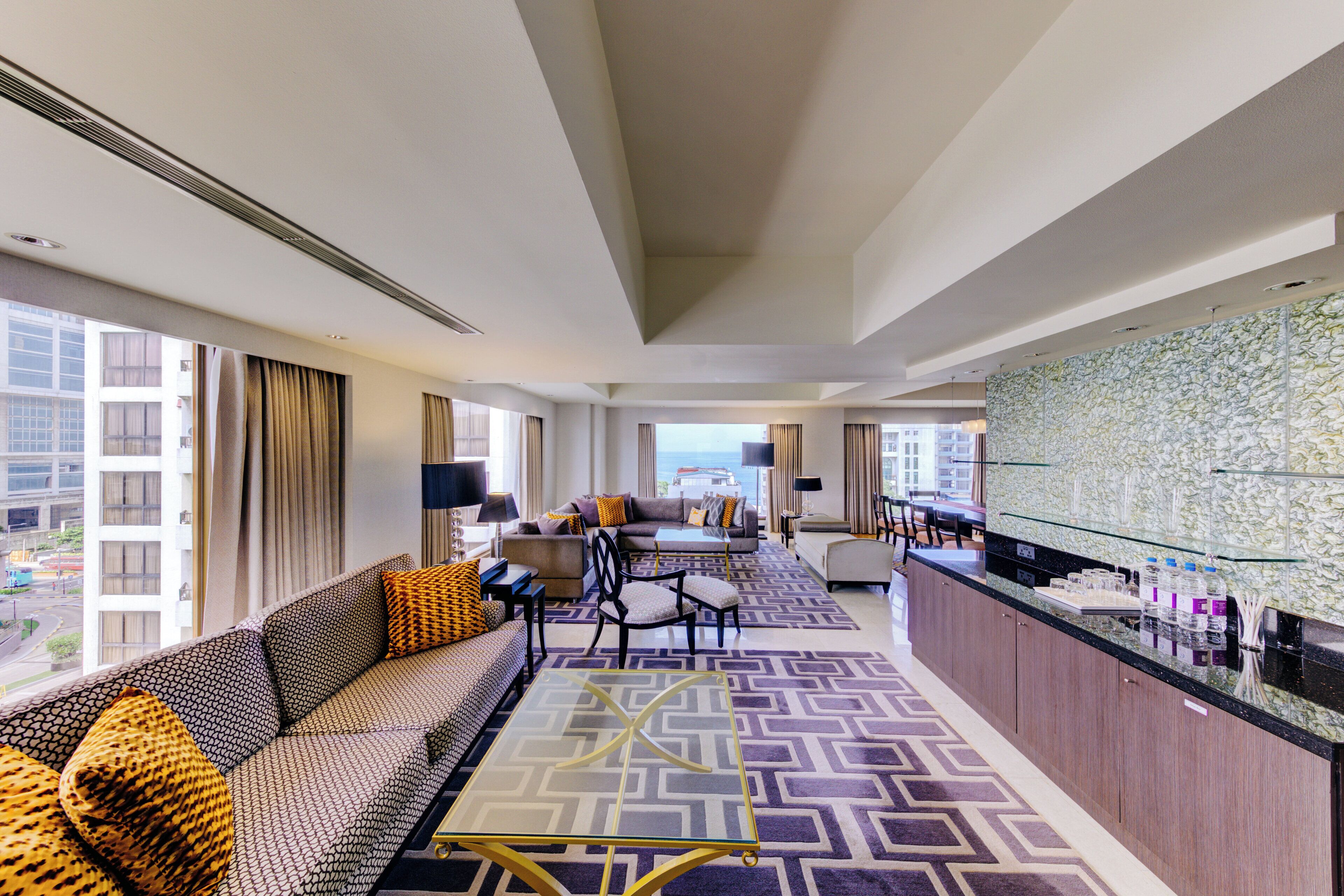 Un hall de hotel con un sofá, sillas, una mesa de centro y un mostrador de recepción.
