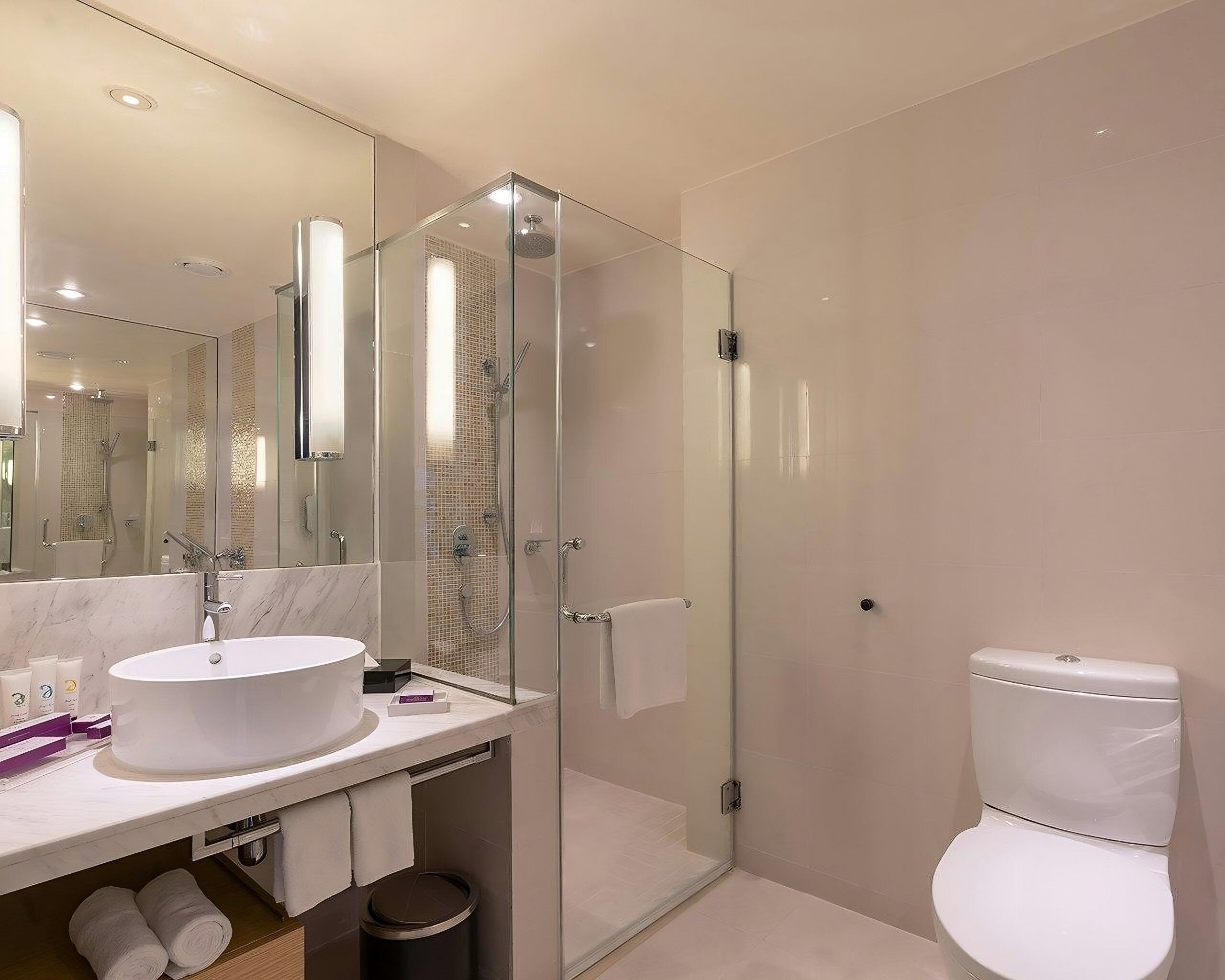 Un bagno moderno con doccia vetrata, lavandino bianco e water.