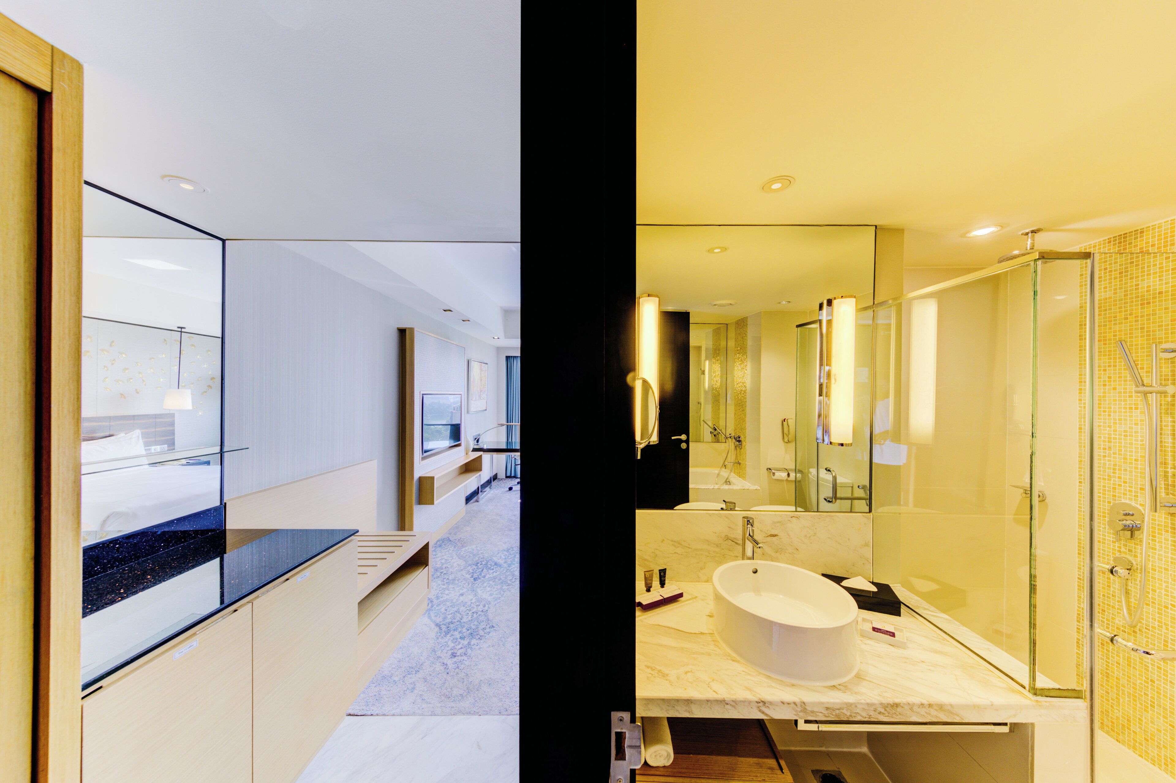 A modern bathroom with a large mirror, a bathtub, and a shower area.