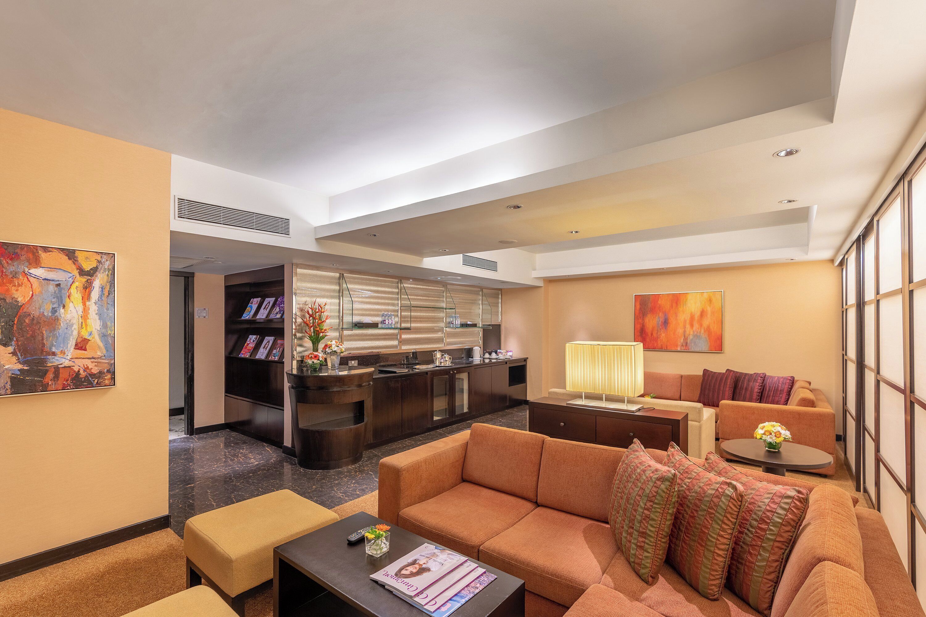 A hotel lobby with a sofa, coffee table, and a reception desk.