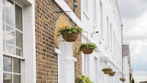 A row of white buildings with brick facades and hanging flower baskets. - The Clarendon Hotel - Blackheath (London)