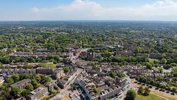 An aerial view of a densely populated urban area with a mix of residential and commercial buildings, roads, and green spaces.