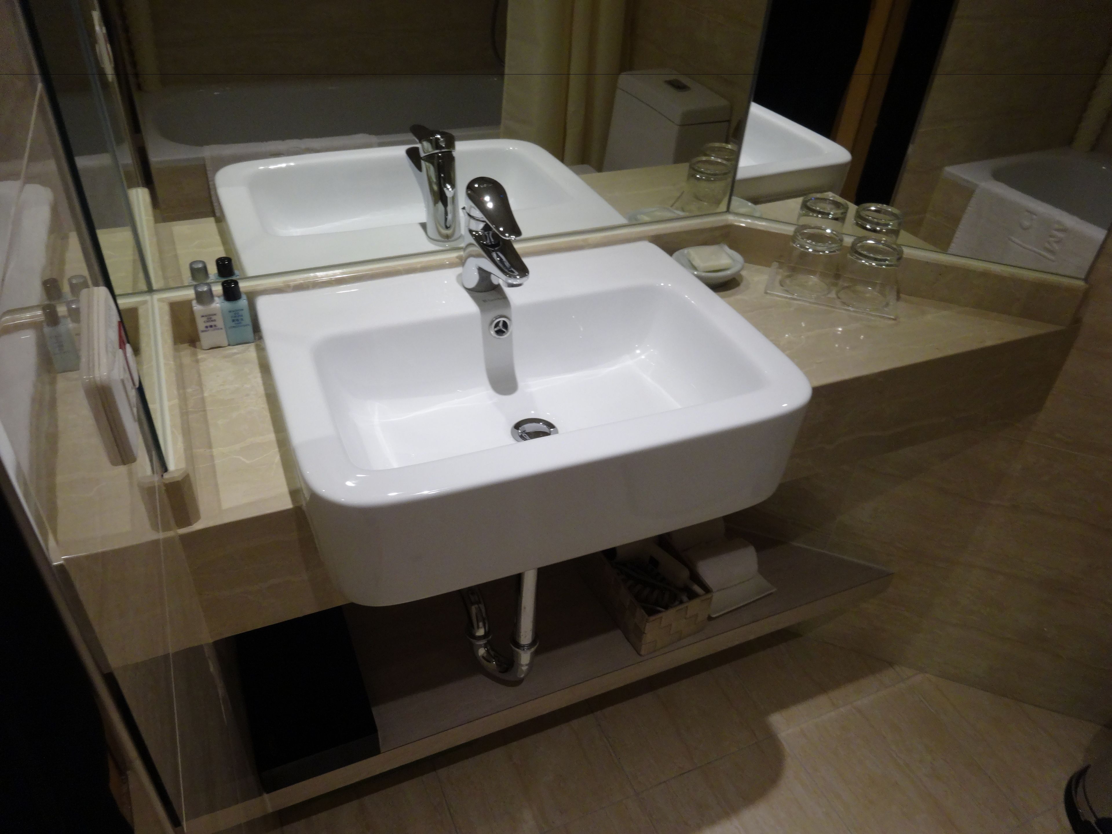A modern bathroom with two sinks, a mirror, and a glass shower enclosure.