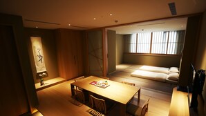 A modern hotel room with a wooden dining table, chairs, a sofa, and a large window with blinds. - Maison de Chine Hotel Chiayi (Chiayi City)