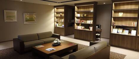 A modern living room with a sectional sofa, a coffee table, and built-in bookshelves.