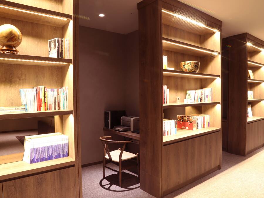 A library with wooden bookshelves, a globe, and a printer.