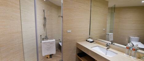 A modern bathroom with a glass shower enclosure, a large mirror, and a vanity with two sinks.