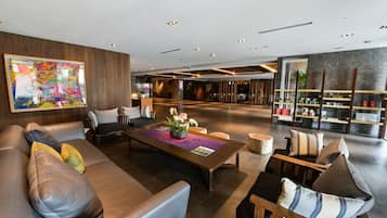 A modern lobby with a leather sofa, a wooden coffee table, and a reception desk.